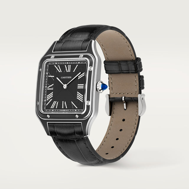 The Cartier Santos-Dumont watch features a rectangular black dial with Roman numerals, steel case, black leather strap, mechanical movement, and a blue crown gemstone, shown on a plain white background.
