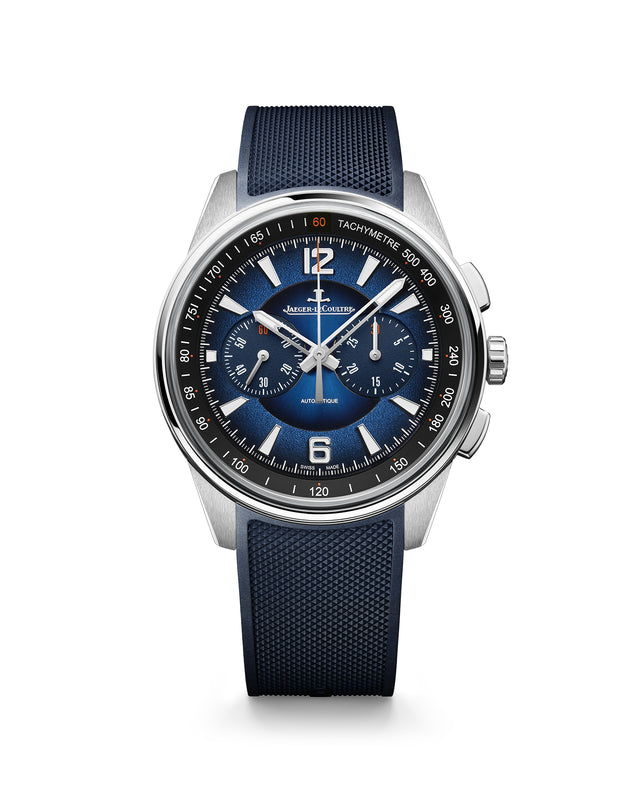 The Jaeger-LeCoultre Polaris Chronograph features a blue textured strap, blue lacquered dial with silver indices, three sub-dials, tachymeter bezel, and steel case. Bold numerals at 12, 3, and 6 contrast against a white background.